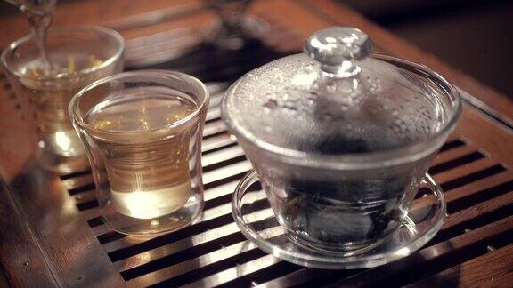 将绿茶倒入木桌上的玻璃碗中中国茶道