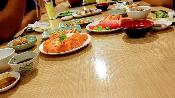 在一家日本餐馆里一群朋友用筷子吃寿司