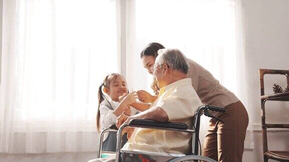 多代母女在家中照顾老爷爷坐在轮椅上幸福快乐老人养老理念