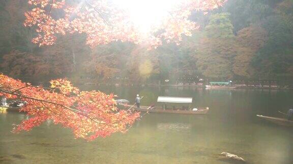 在岚山秋叶林中的桂河上的一艘小船