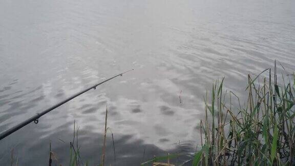 捕鱼浮在水上的特写镜头水上钓鱼竿以河水为背景的钓竿渔民的生活方式湖上钓鱼等着大鱼上钩