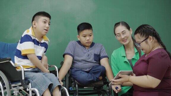 小组亚洲儿童残疾轮椅自闭症做平板电脑演示活动与教师教室提高学习技能的活动贫困儿童教育