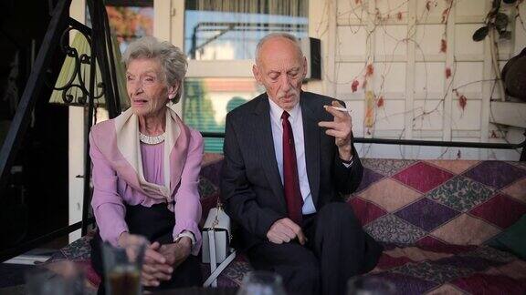 一对优雅的老年夫妇坐在前廊