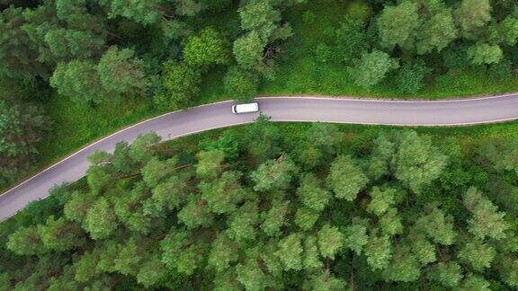 航拍红色汽车行驶在松树林中的道路上森林自驾游夏日风光鸟瞰图红色汽车行驶在柏油路穿越广阔的森林在夏日