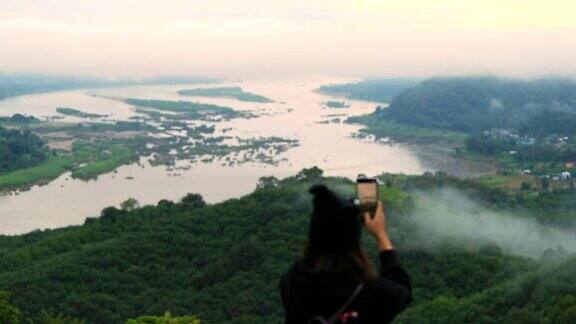 亚洲女性放松用智能手机拍摄山景和湄公河慢镜头概念女性独自旅行