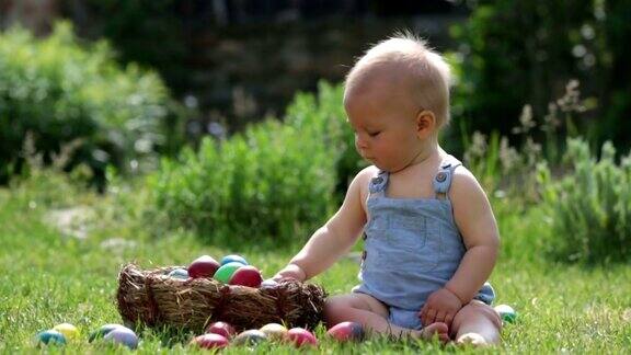 可爱的孩子在盛开的花园里玩着小兔子和复活节彩蛋春天男孩玩兔子找鸡蛋过节