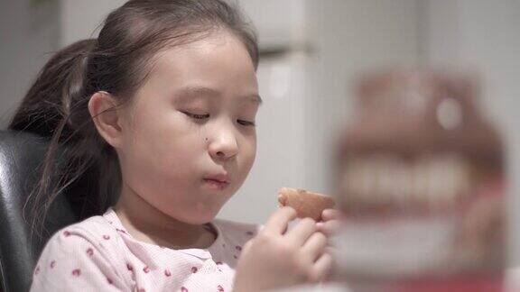 这个亚洲小女孩喜欢早餐吃面包