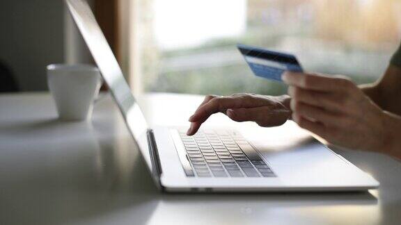 网上购物用笔记本和信用卡付账的女人