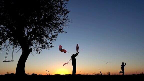 日落时分和爷爷一起放风筝的小男孩