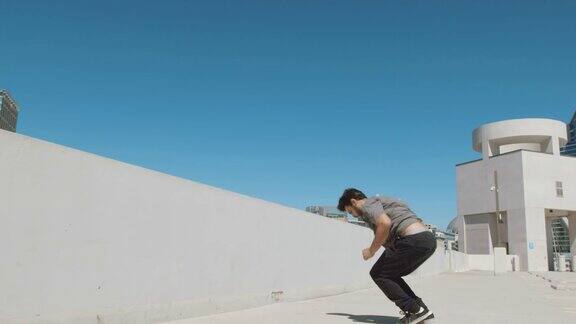 慢动作跑酷运动员做极限后空翻在城市外隔离在天空的墙壁