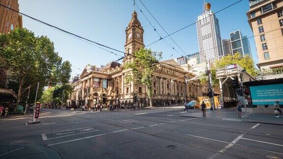 在澳大利亚维多利亚州墨尔本市的墨尔本市政厅拥挤的通勤者和游客步行和穿过斯旺斯顿街和柯林斯街的时间推移