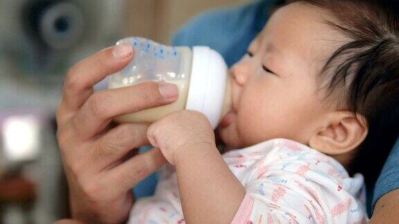 父亲在家用奶瓶喂亚洲女婴