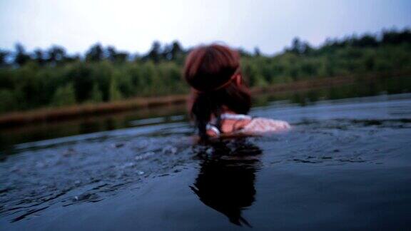 飘渺的嬉皮女孩凝视着平静的水面上的你