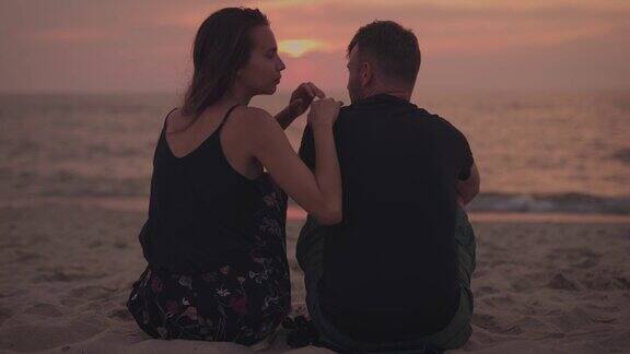 夕阳下浪漫的情侣一个男人和一个女人在海边