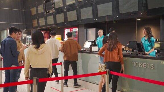 后景亚洲华人人群排队购买电影票和快餐在电影院电影院