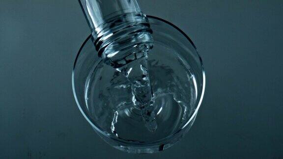 瓶子倒纯净水到透明杯子特写俯视图液体填充