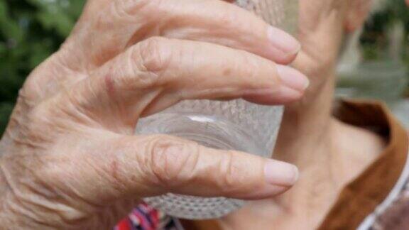 老妇人吃着药喝着水奶奶把药片放进嘴里医疗保健和医疗理念特写慢动作