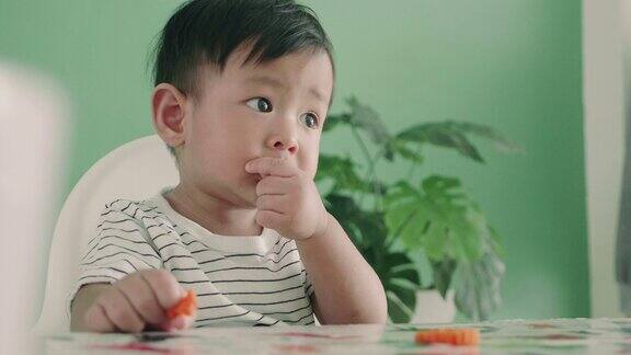 亚洲小男孩在吃胡萝卜特写