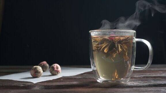 绿茶花蕾在玻璃茶杯中绽放