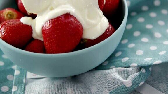 特写新鲜草莓与奶油在碗