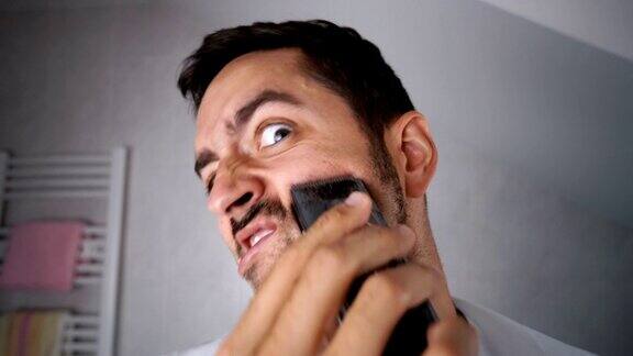 男人用剃须刀刮胡子