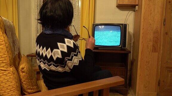 一个妇女住在一个石头村庄的房子里前面是一台旧电视