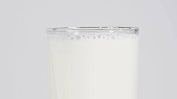 近距离倒新鲜牛奶在玻璃上的白色