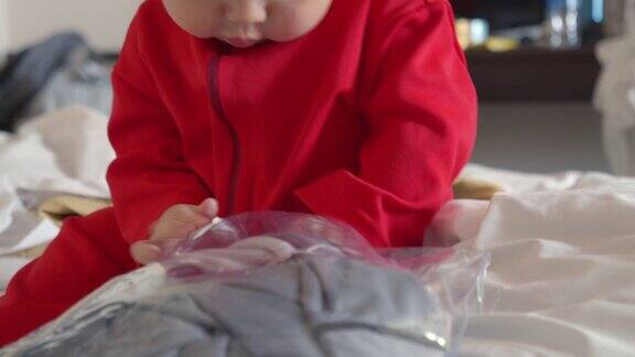 亚洲8个月的女婴在红色的裙子喜欢玩在白色的床上在家