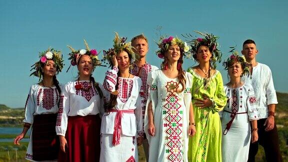 一群穿着民族服装的歌手乡村风景优美斯拉夫民族的传统和习俗以刺绣和花环的妇女的头4kProRes