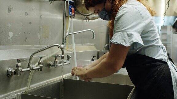 Covid-19爆发期间餐厅工作人员在大水槽中洗手