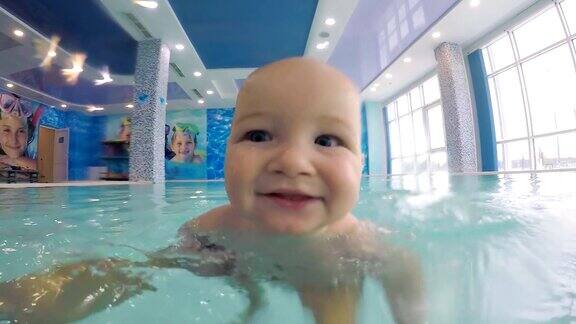 在游泳池游泳时婴儿的脸的特写