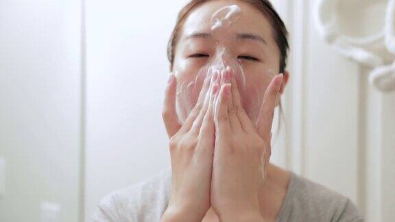 年轻的亚洲妇女洗脸