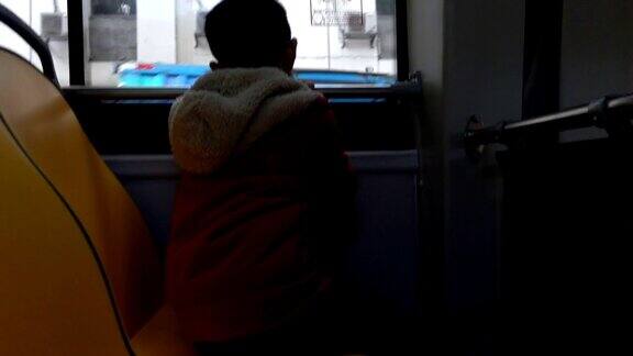 坐在公共汽车里的亚洲男孩
