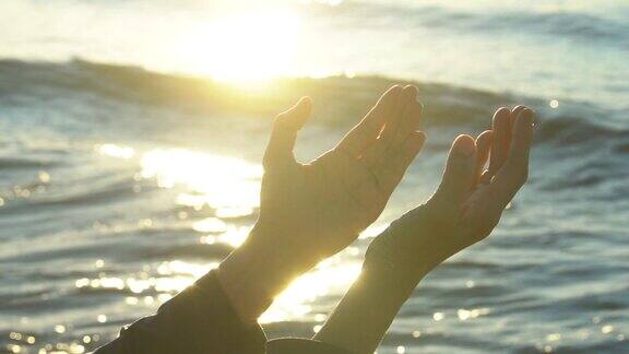 在日落背景下女人双手祈祷上帝的祝福