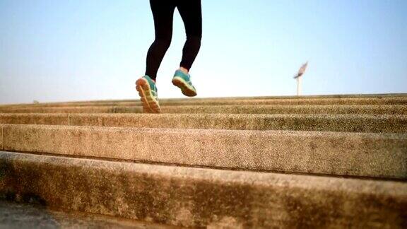 近距离观察亚洲年轻健身女性在楼梯上跑步