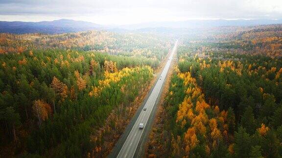 路上有黄色和绿色的树在秋天的山上日落