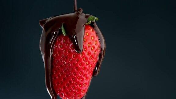 草莓在黑色背景上旋转上面覆盖着巧克力