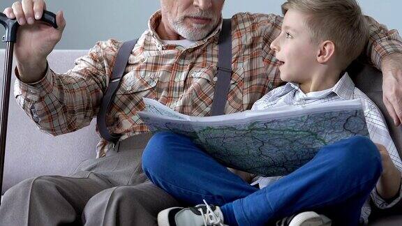 学校男孩在爷爷的帮助下学习世界地图老人分享知识