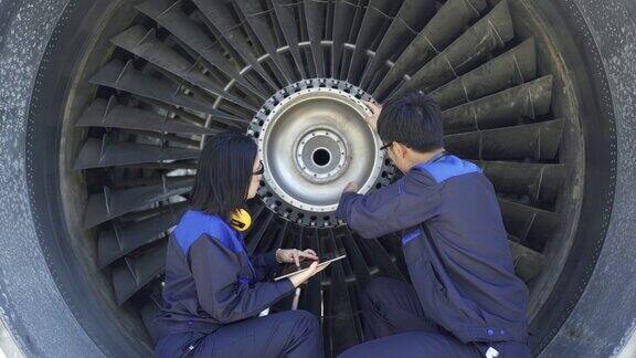 飞机工程师使用数码平板电脑修理喷气发动机