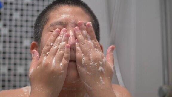 快乐的亚洲少年在家里洗澡慢镜头