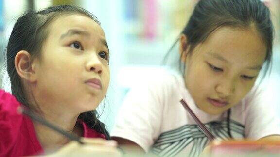 两个亚洲女孩一起通过智能手机在线学习