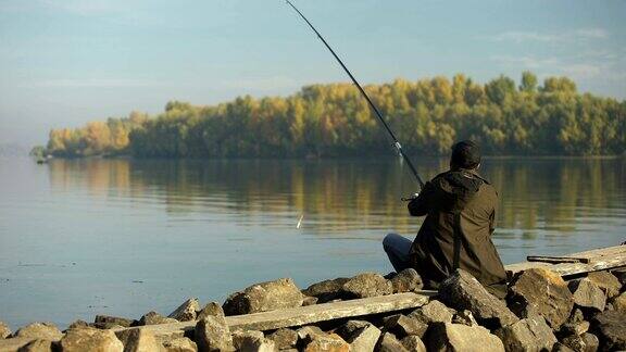 单身渔夫抛钓竿等待鱼儿美丽的大自然爱好