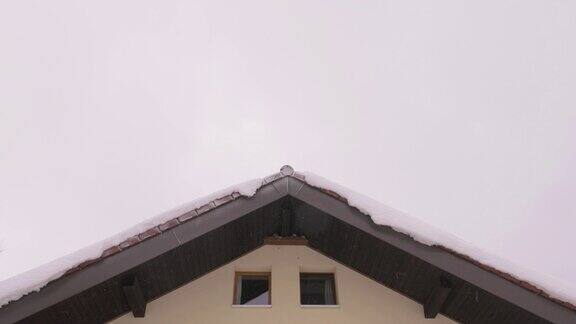 三角形屋顶与雪悬挂在屋檐上