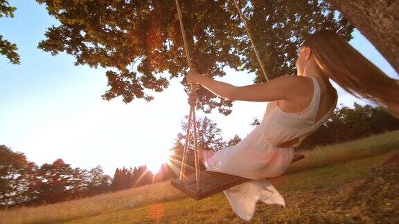 SLOMO女人在日落摆动白色连衣裙