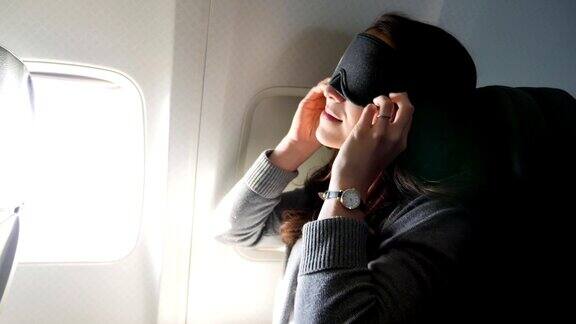一名年轻女子在长途飞行中使用睡眠面罩