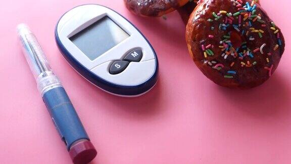 糖尿病测量工具胰岛素和甜甜圈上粉红