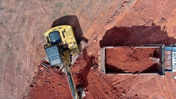 挖掘机正把土装进自卸卡车