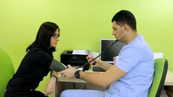 一位年轻的医生给病人量血压