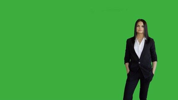 年轻迷人的黑发女人站在孤立的绿色屏幕背景美丽的职业装女人像
