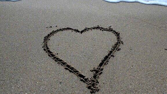 海浪冲刷着沙滩上的心爱与心碎